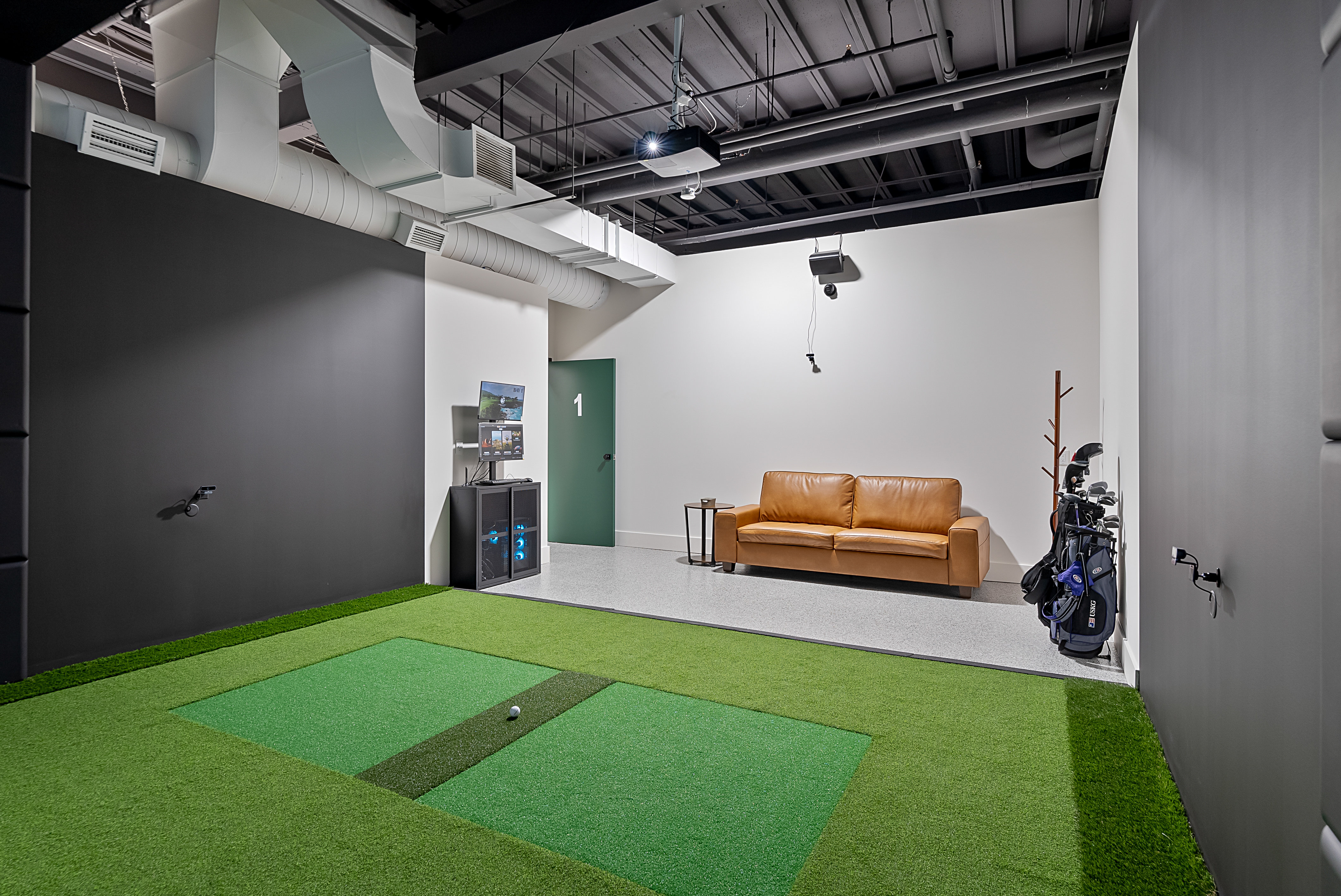 Private simulator bay with lounge seating and finished walls